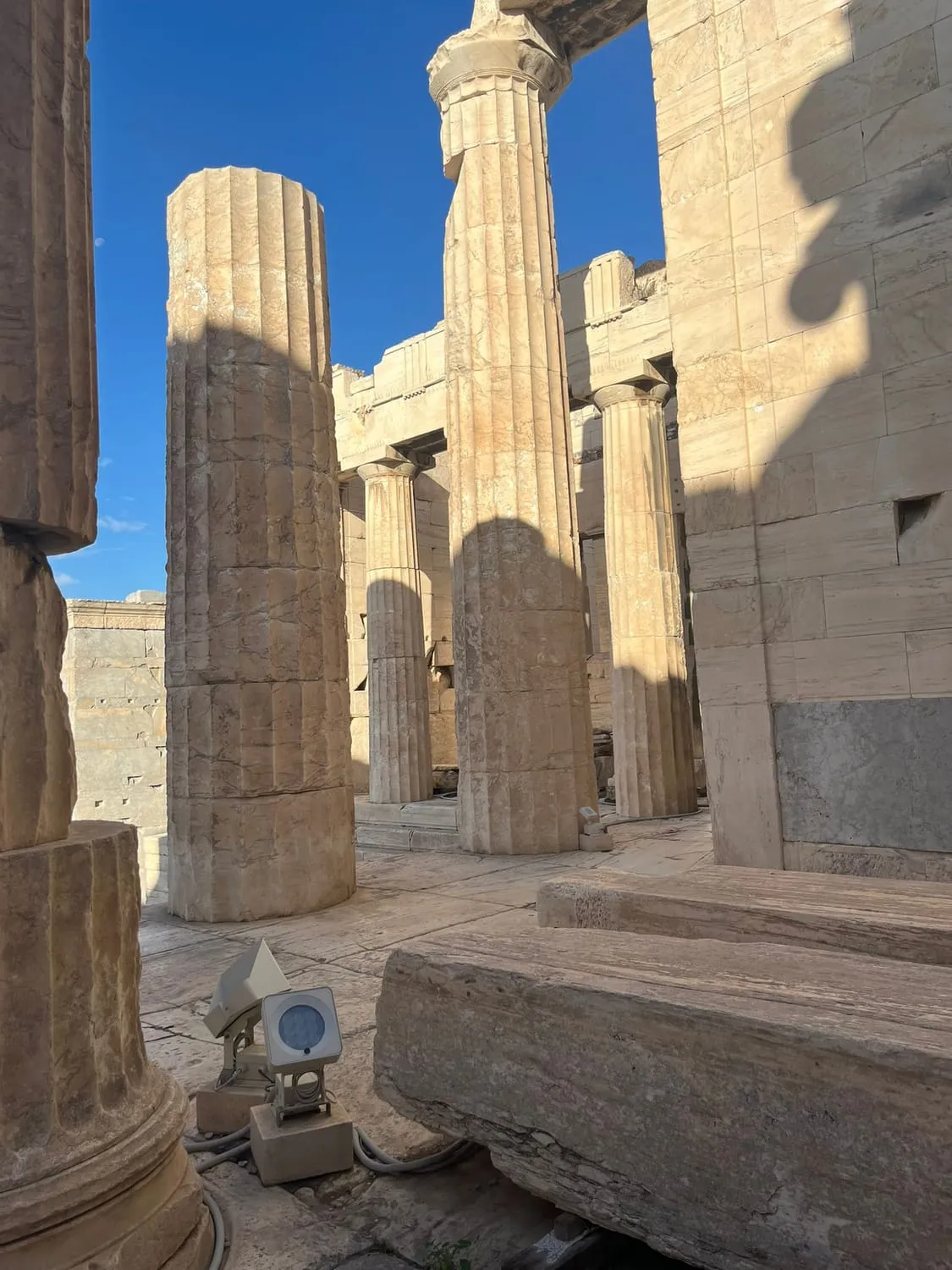 Weathered stone columns of an ancient temple against a pale sky.